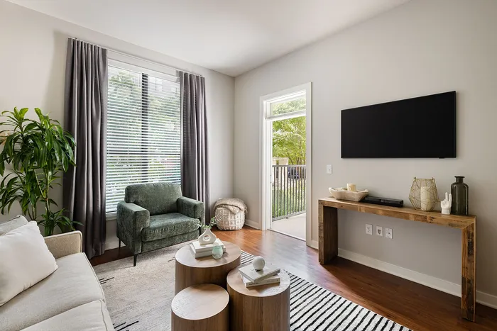 Chic living room with modern decor, cozy seating, and natural light streaming through large windows.