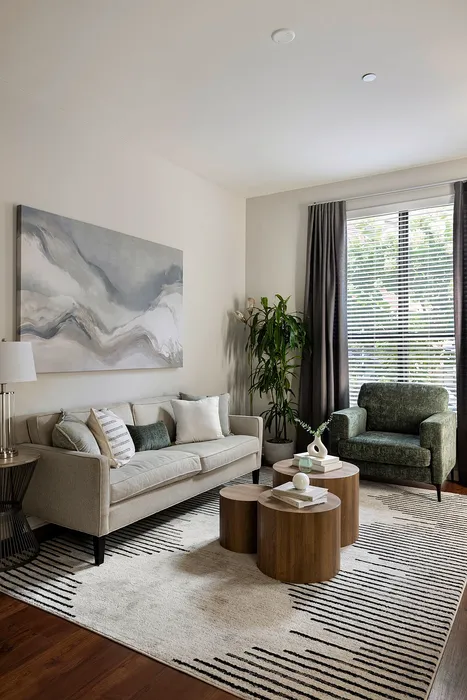 Chic living room with modern artwork, cozy beige sofa, and stylish wooden coffee tables.