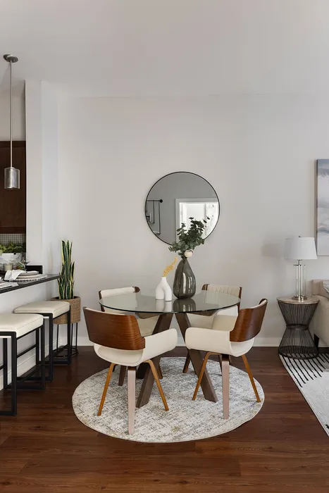 Elegant dining area with a modern glass table, stylish chairs, and chic decor, perfect for entertaining.