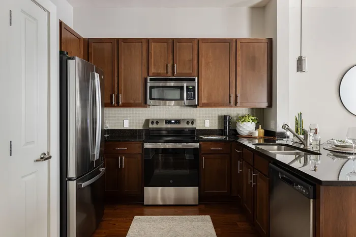 Sleek modern kitchen featuring rich wooden cabinetry, stainless steel appliances, and elegant granite countertops.