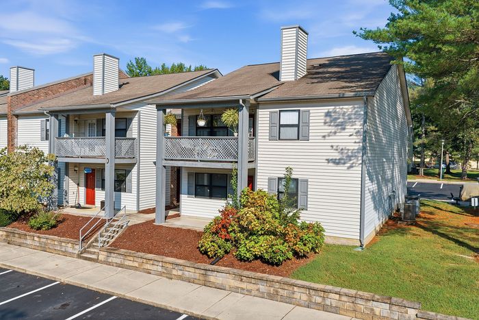 Charming apartment complex with modern architecture, featuring spacious balconies and lush landscaping.