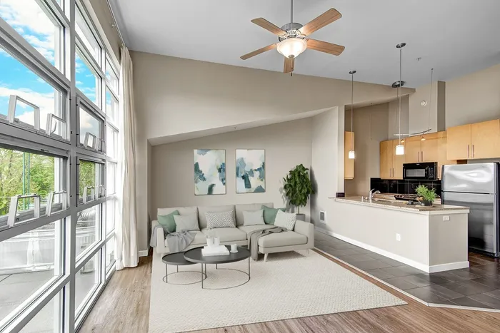 ample living room filled with furniture and a ceiling fan.
