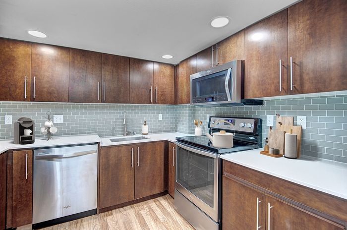 a kitchen with wooden cabinets and stainless steel appliances.