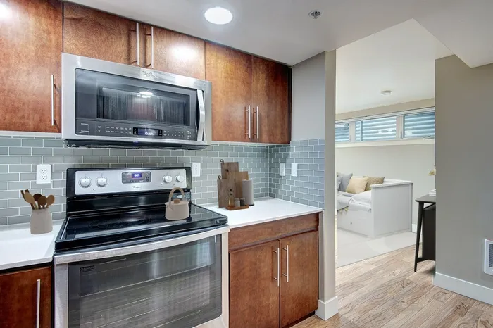 a kitchen with wood cabinets and a stainless steel oven and microwave