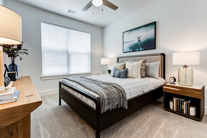 Room with bed, two end tables, dresser with window