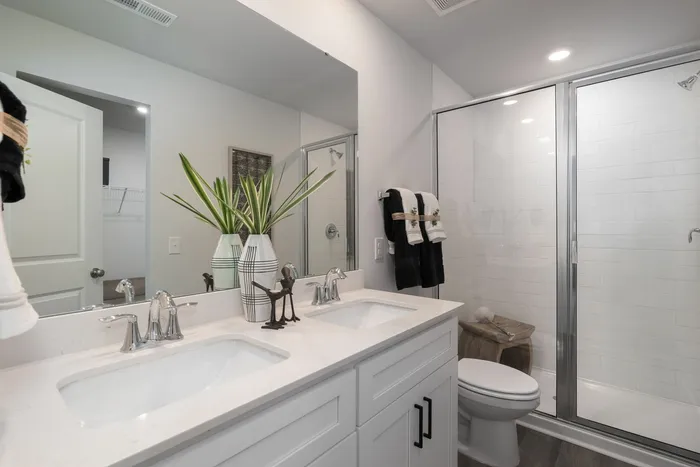 Primary Bathroom with double vanity and glass shower