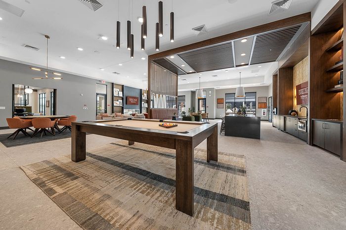 Interior clubhouse with lounge seating, ceiling lights, pool table
