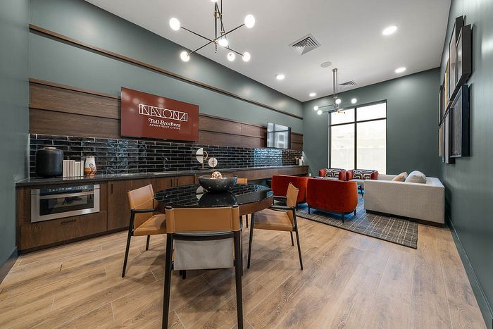 Interior clubhouse with kitchen, lounge seating, ceiling lights
