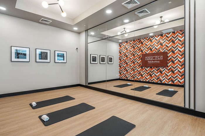 Navona interior fitness center stretch room, large mirrors, ceiling lighting, mounted flat screen tv