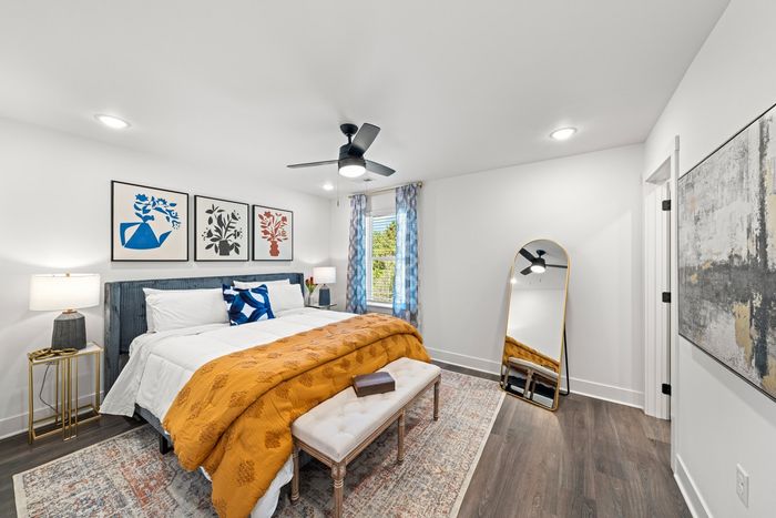 Furnished bedroom with bed, lighted ceiling fan, and one window
