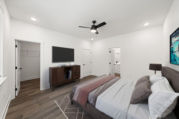 Furnished bedroom with lighted ceiling fan and bed