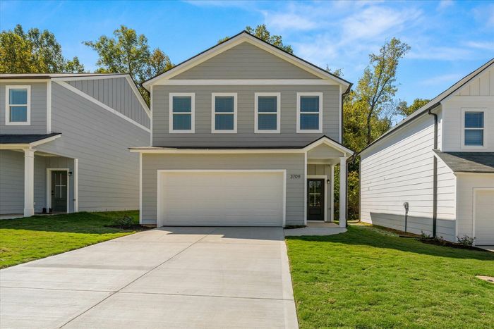 Exterior of front of home with two car garage and driveway in the daytime