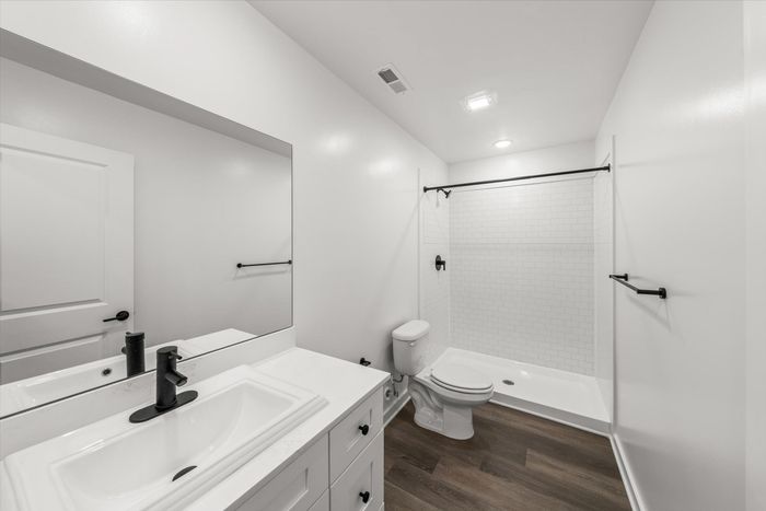 Bathroom with one sink and large mirror above with standing shower