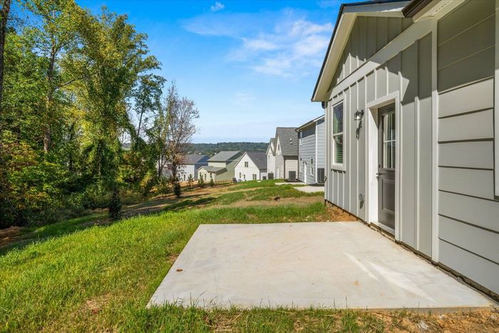 Exterior of back of home with paved patio and grass