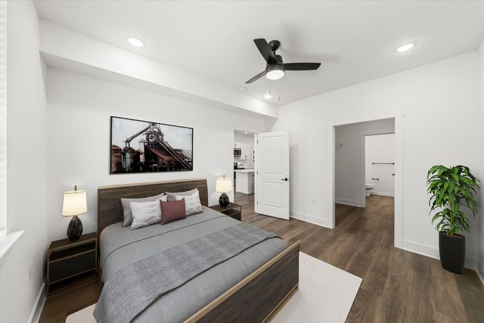 Furnished Main bedroom with bed, side tables, and lighted ceiling fan