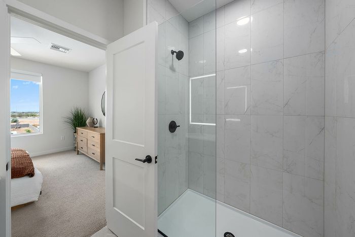 Navona bathroom, glass-enclosed shower with tile surround, ceiling lighting