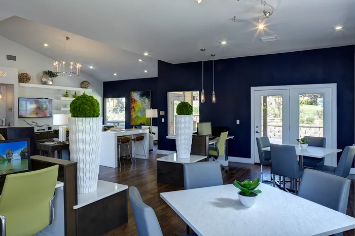 Stylishly designed lounge area with modern decor, featuring white tables, colorful chairs, and elegant lighting.