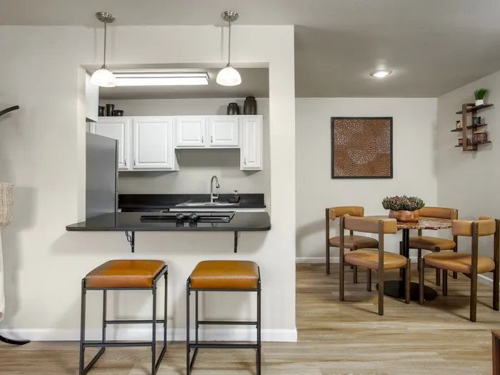 Bright open kitchen with modern white cabinetry, stainless steel appliances, and a cozy dining area.