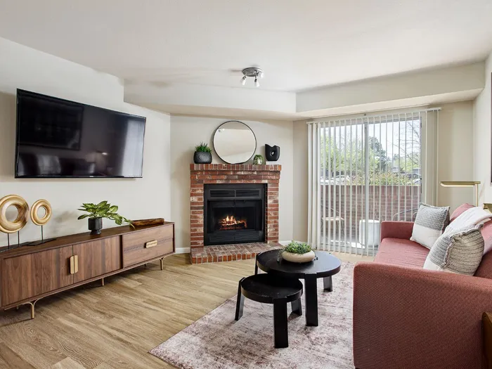 Inviting living room with a brick fireplace, elegant decor, and large window for natural light.