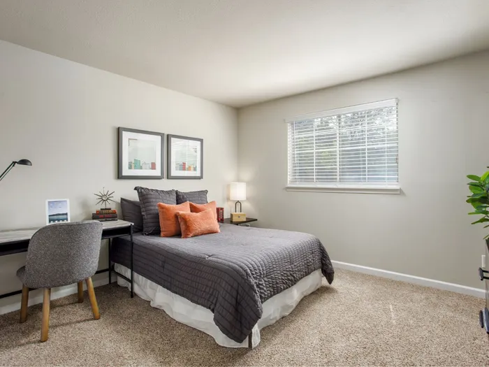 Cozy bedroom with modern decor, featuring a stylish bed, artistic wall art, and sleek furniture.