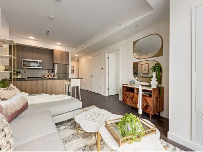 Modern open-concept living room at One Park with sleek built-in shelving, neutral furnishings, a soft area rug, and large windows bringing in natural light.