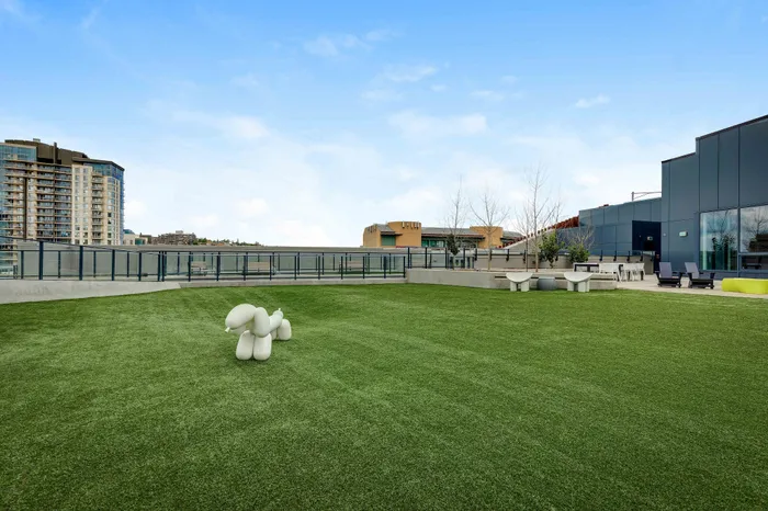 Expansive rooftop terrace with lush green lawn, modern seating, and skyline views, perfect for relaxation and gatherings.