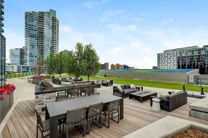 Luxe urban terrace with sleek outdoor seating, lush greenery, and breathtaking cityscape views, perfect for entertainment and relaxation.
