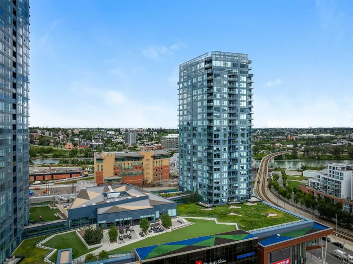 Breathtaking urban skyline view featuring modern glass high-rises, lush park areas, and a vibrant cityscape under a clear blue sky.