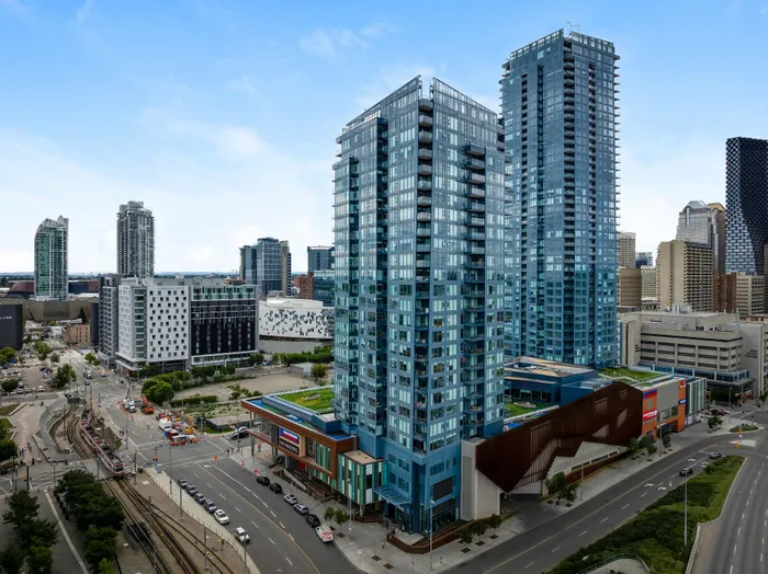 Modern high-rise apartments with sleek glass exterior, featuring vibrant urban setting and stunning city views.