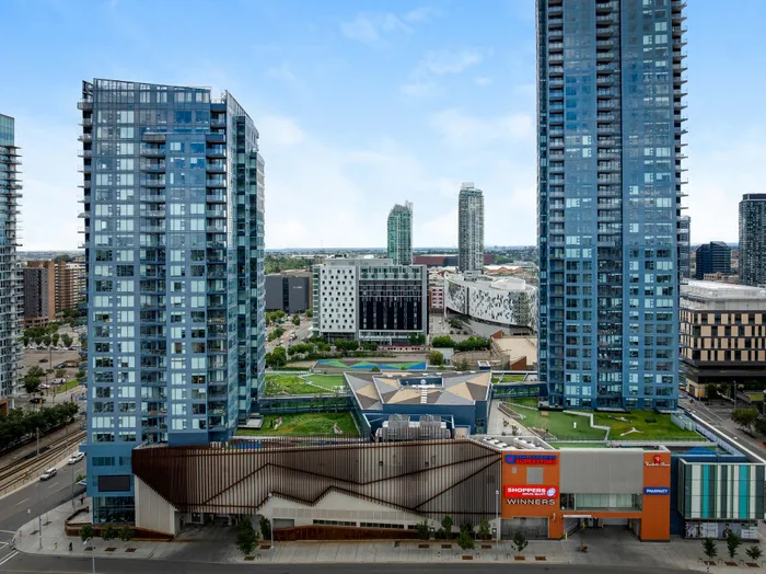 Vibrant urban skyline showcasing sleek modern high-rises with abundant glass facades, surrounded by well-manicured green spaces and convenient shopping amenities at street level.