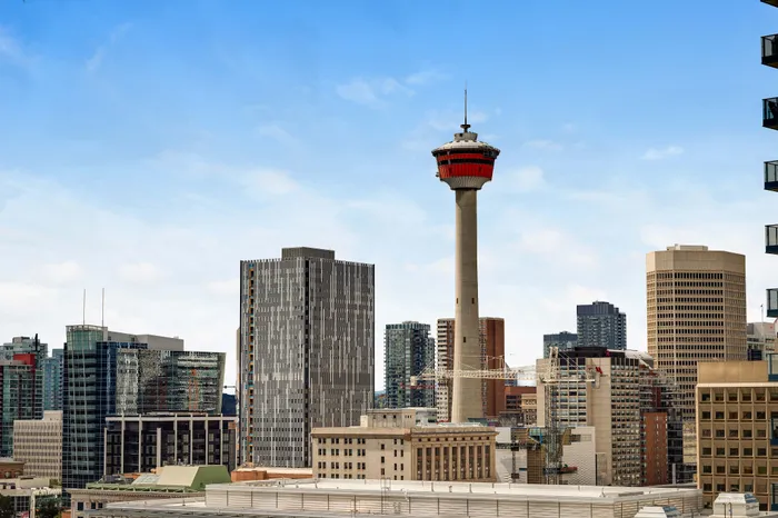 Breathtaking city skyline featuring modern architecture and a prominent observation tower, under a clear blue sky.