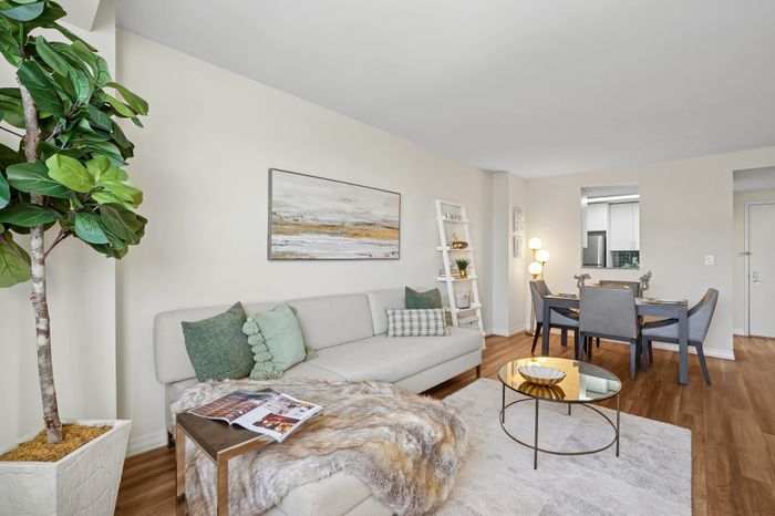 Elegant living and dining area featuring a cozy sofa, stylish decor, and a modern dining table. Bright and inviting with natural light and chic furnishings.