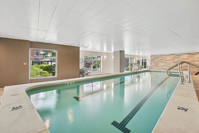 Luxurious indoor swimming pool with elegant seating and bright natural light.