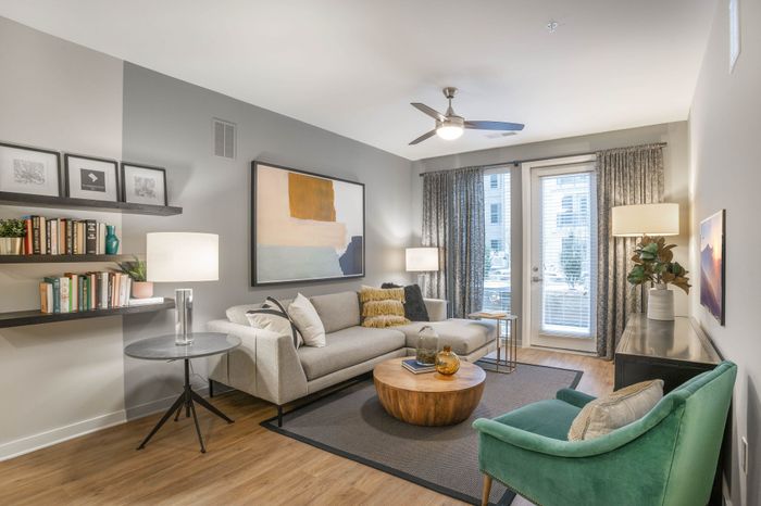 Bright and inviting living room with contemporary decor, cozy sectional sofa, elegant artwork, and a stylish coffee table, perfect for relaxation and entertaining.