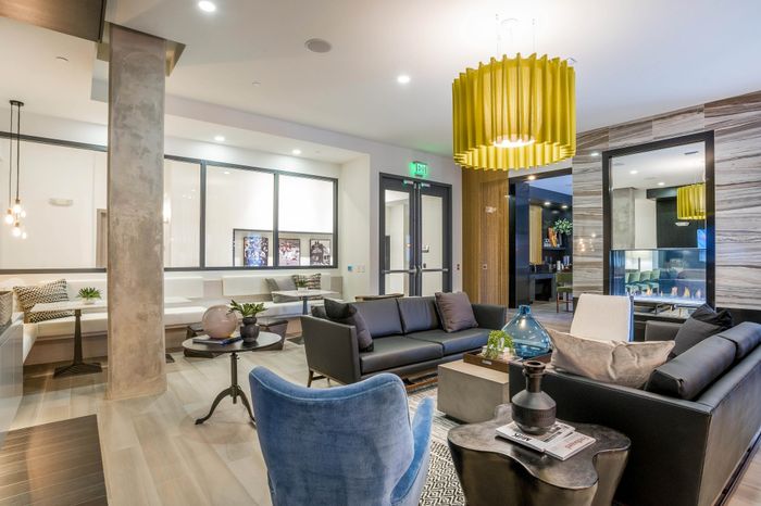 Modern and inviting lounge area with elegant seating, a chic yellow pendant light, and contemporary decor.