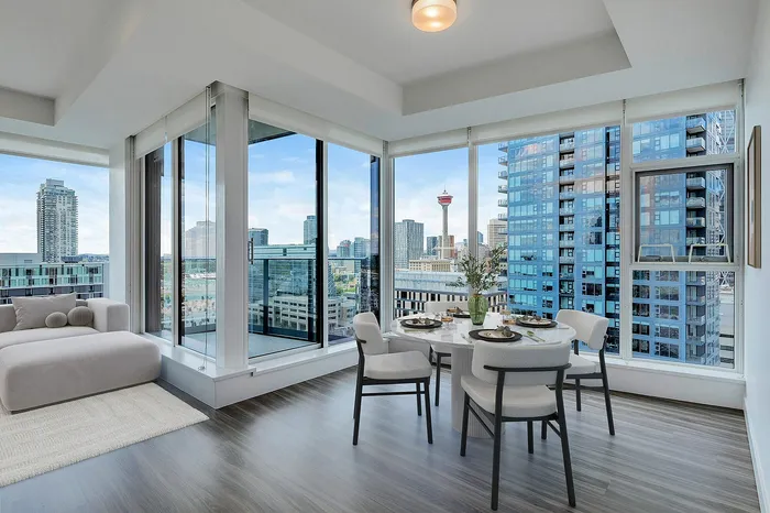 Breathtaking urban apartment featuring an elegant dining area, cozy modern seating, and panoramic cityscape views through floor-to-ceiling windows.