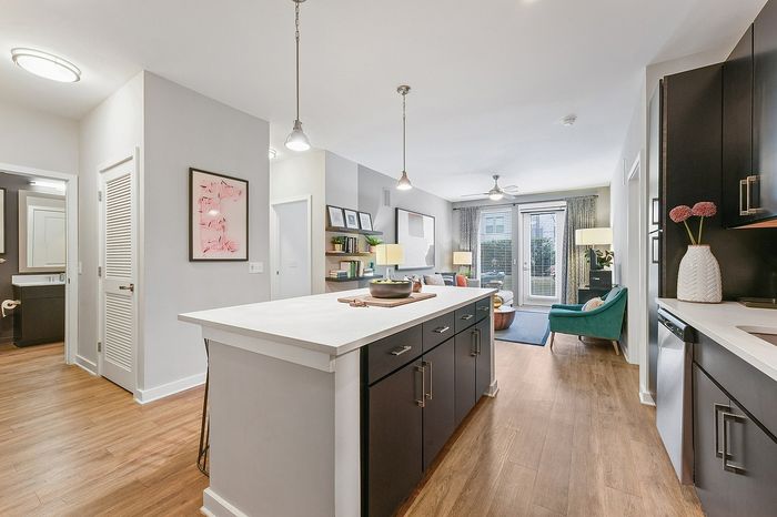 Modern open-concept kitchen and living area with sleek cabinetry, elegant island, and cozy seating, flooded with natural light.