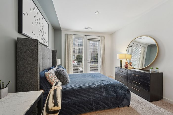 Inviting bedroom with a plush bed, stylish decor, and abundant natural light from large windows overlooking a serene view.
