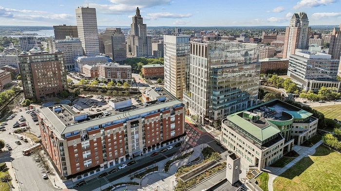 Aerial view of a vibrant cityscape featuring modern skyscrapers, diverse architecture, and lush green spaces, perfect for urban living.