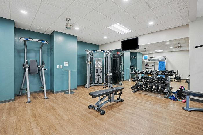 Modern fitness center with state-of-the-art equipment, featuring free weights, a multi-functional trainer, and sleek design, ideal for an energetic lifestyle.