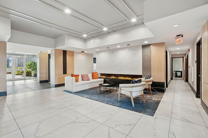 Luxurious apartment lobby with modern design, featuring elegant marble floors, stylish seating area, and ambient lighting.