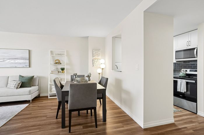 Contemporary open-plan dining area with elegant furniture, adjacent to a sleek modern kitchen and a cozy living room with stylish decor.