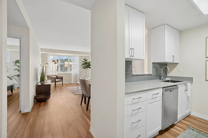 Contemporary open-plan apartment with elegant kitchen, bright dining area, and cozy living space, featuring sleek finishes and abundant natural light.