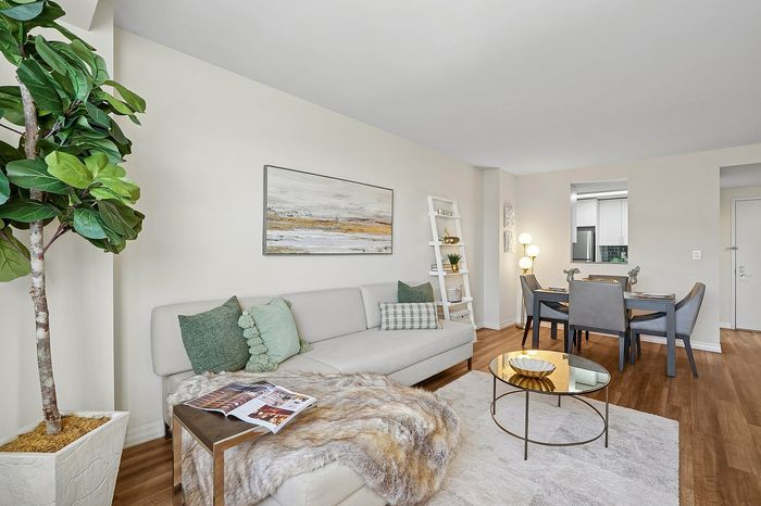 Inviting living and dining area with modern decor, featuring a cozy sofa, chic dining set, and vibrant greenery for a fresh ambiance.
