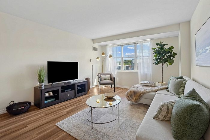 Bright and inviting living room with modern decor, featuring a plush sectional sofa, stylish coffee table, and large window offering scenic views.