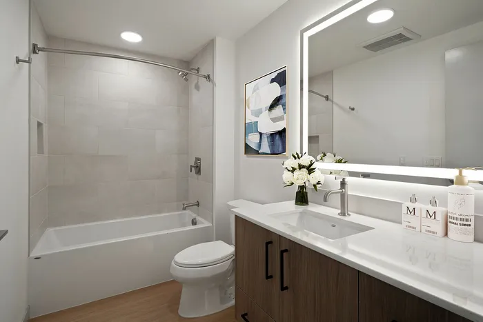 Elegant bathroom with a modern vanity, sleek mirror lighting, and a relaxing bathtub for a spa-like experience.