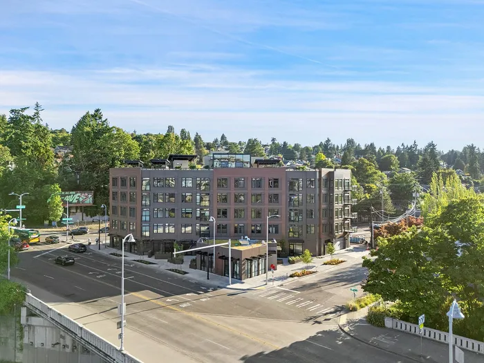 Contemporary urban apartment building surrounded by greenery, highlighting its prime location with tree-lined streets and a vibrant neighborhood skyline.