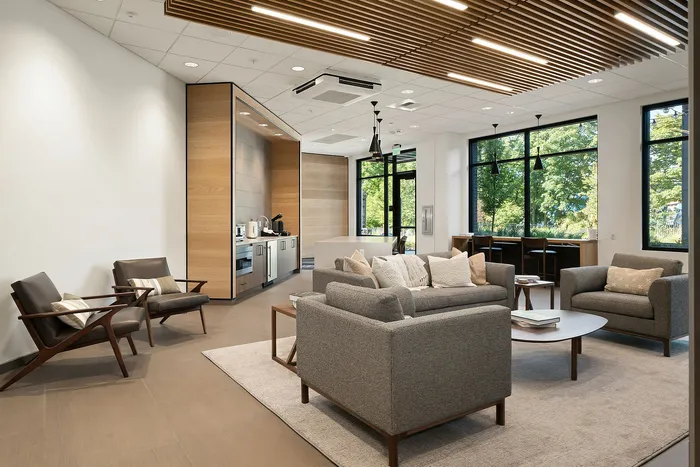 Modern and inviting living space with chic seating, natural light, and a sleek kitchen area, perfect for relaxation and entertaining.
