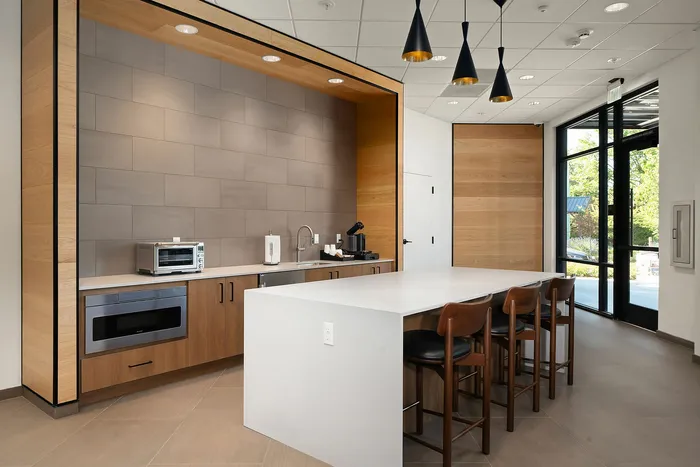 Elegant modern kitchen with sleek wood cabinets, stylish pendant lighting, and a spacious island counter with seating, perfect for entertaining.