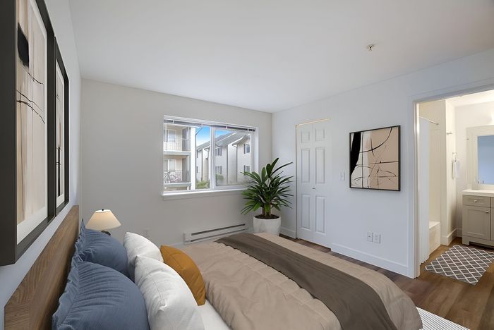 Bright and inviting bedroom with modern decor, large window view, and en-suite bathroom.
